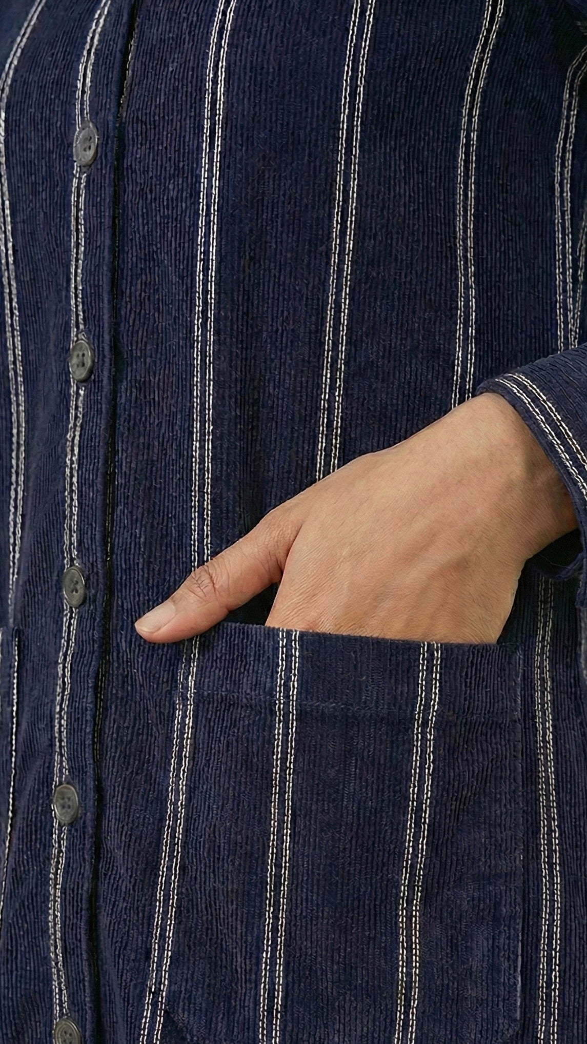 Navy pinstripe shirt with a hand in the pocket