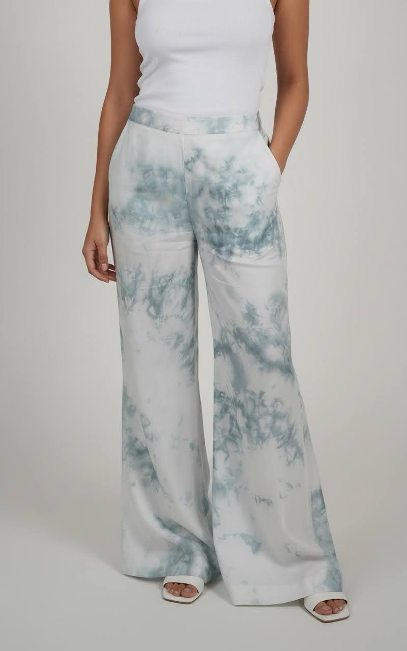 Person wearing light blue tie-dye pants on a plain background