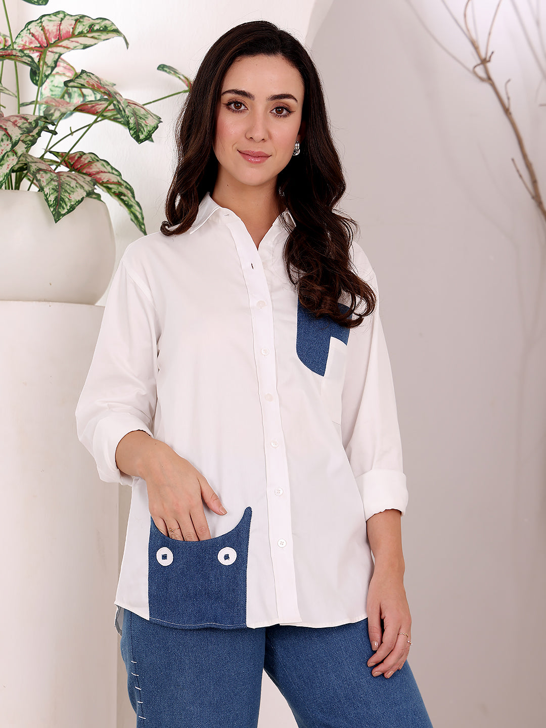 Woman wearing a white shirt with blue accents against a neutral background