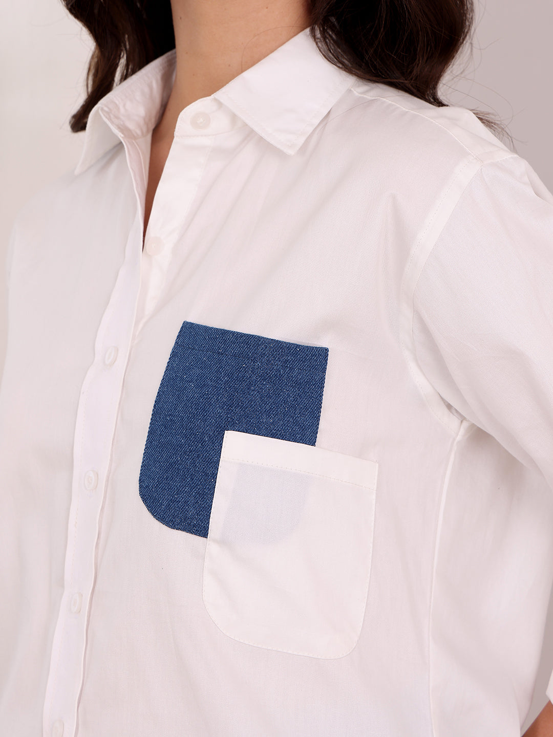 White shirt with a blue square patch on a plain background