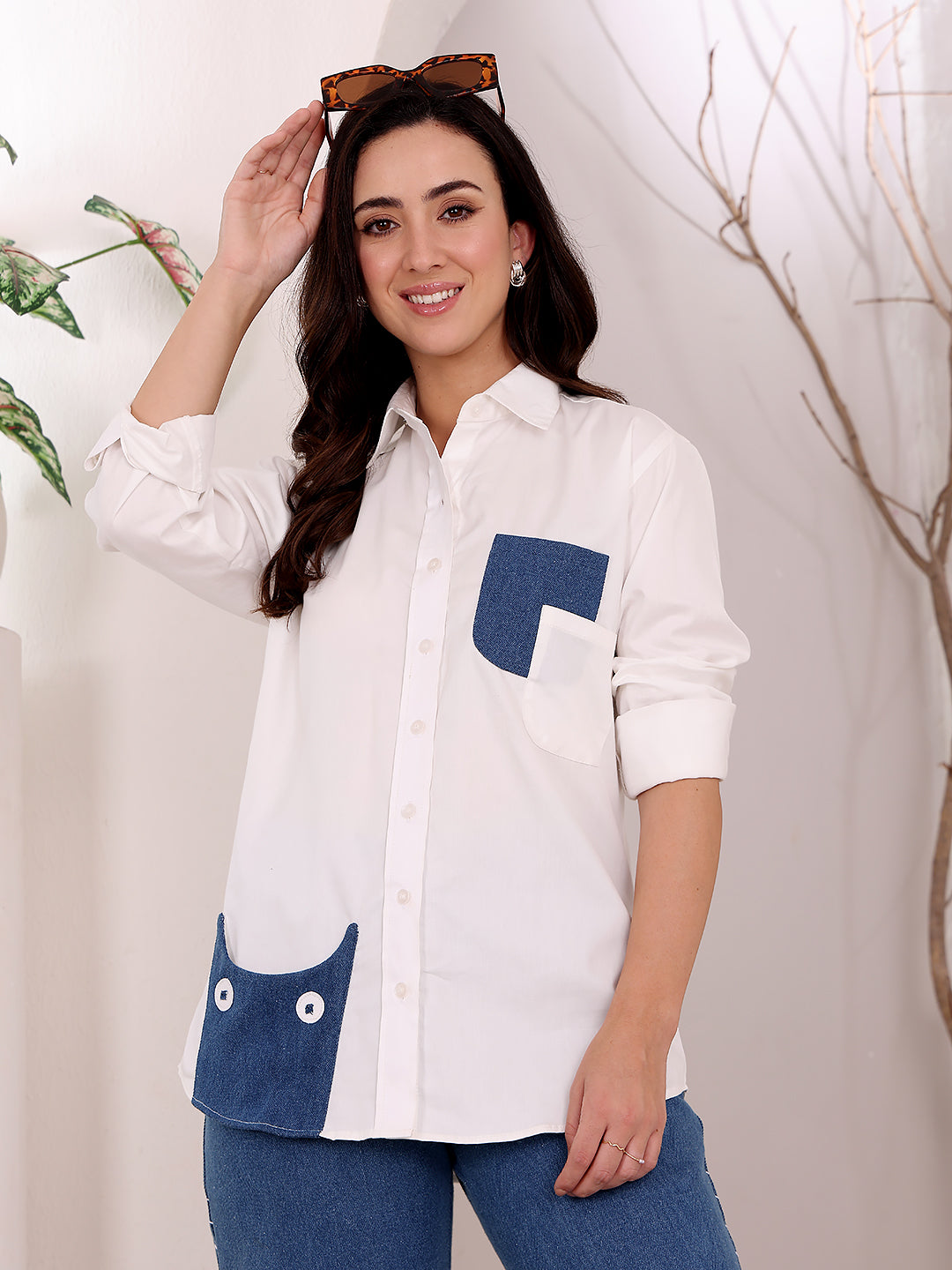 Woman wearing a white shirt with blue accents against a neutral background