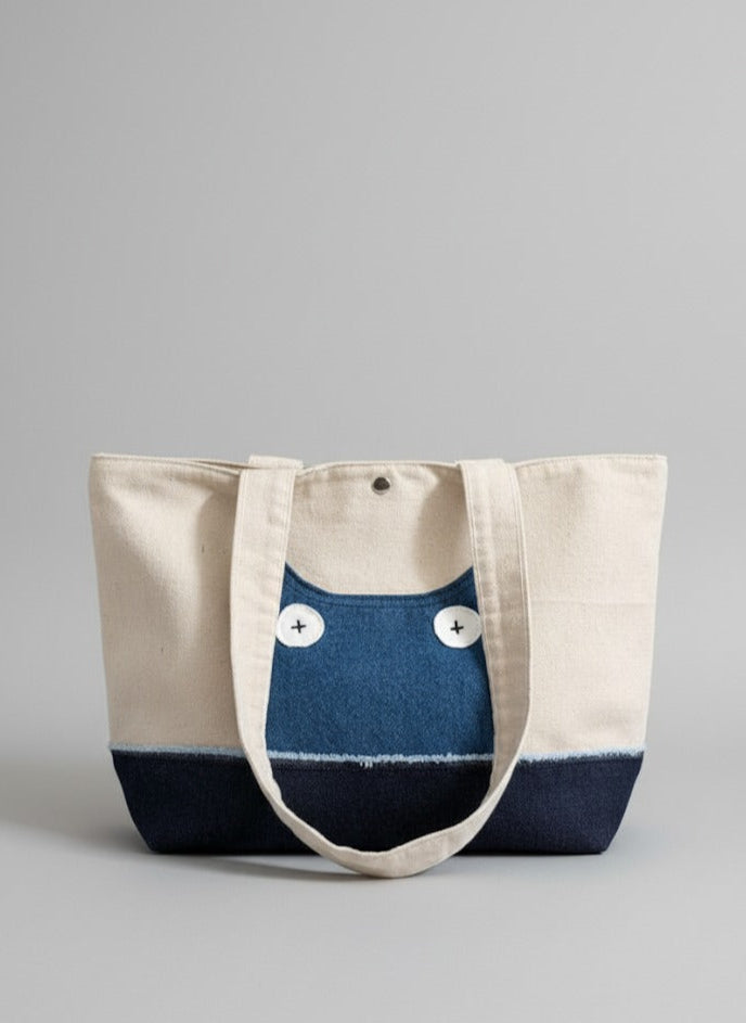 Tote bag with blue and beige design on a gray background