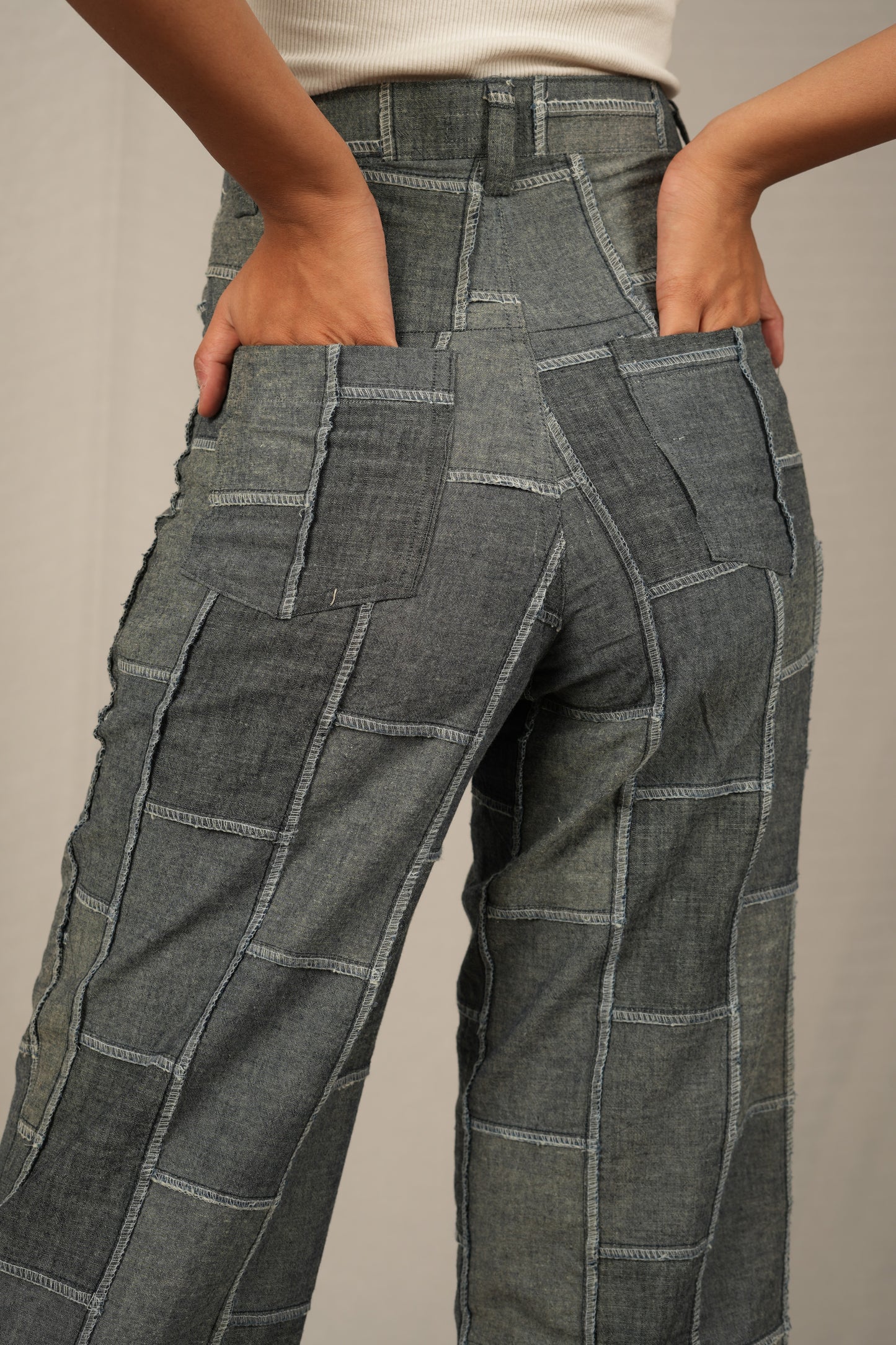 Gray patchwork pants worn by a person on a neutral background