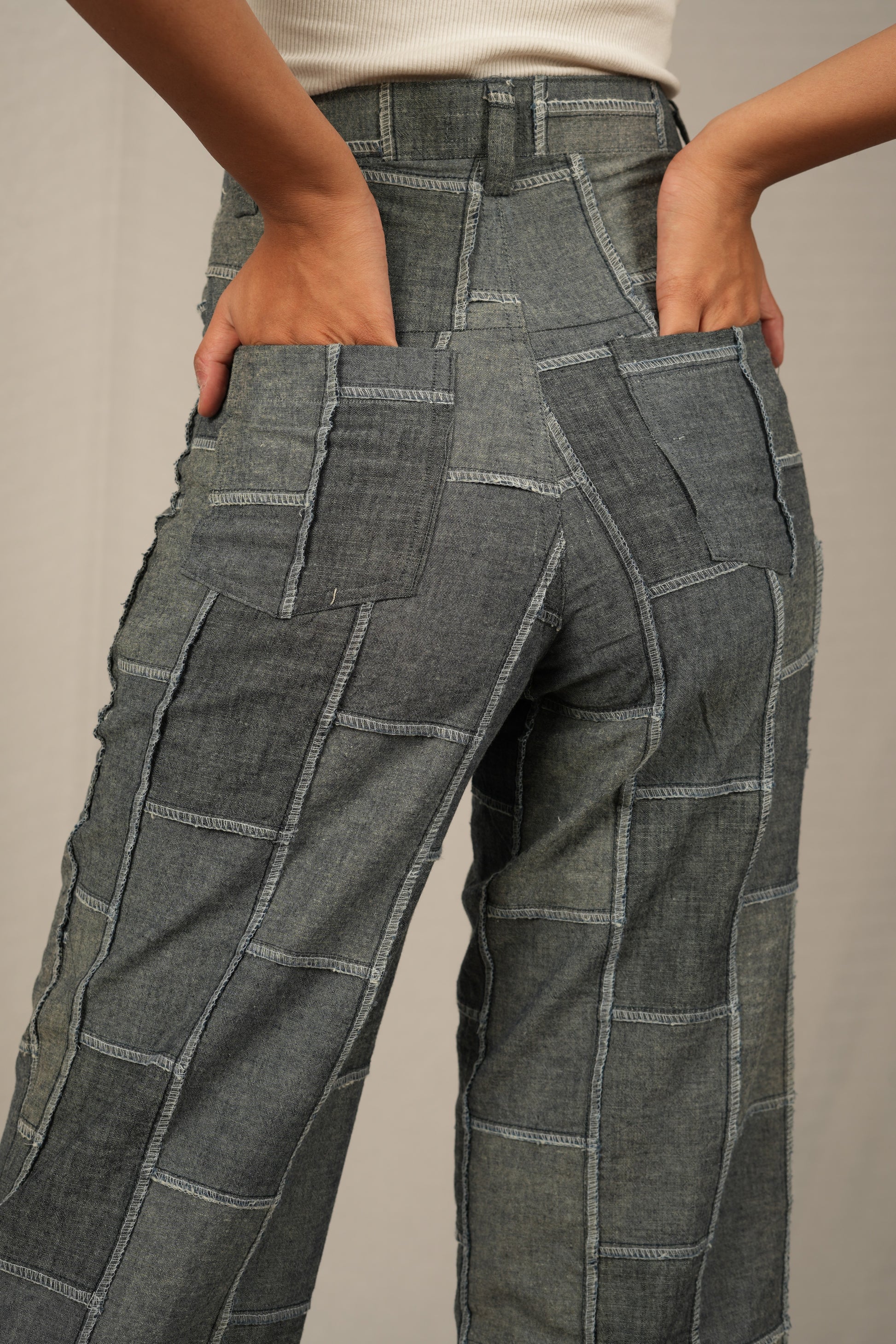 Gray patchwork pants worn by a person on a neutral background