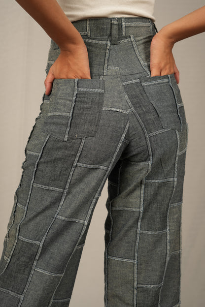 Gray patchwork pants worn by a person on a neutral background