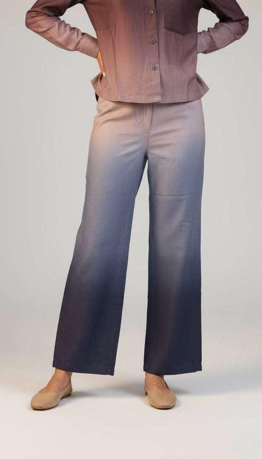 Person wearing a brown shirt and blue jeans on a plain background