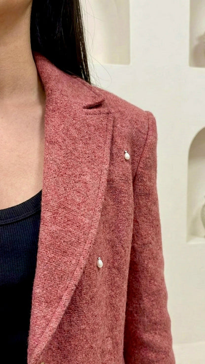 Close-up of a red textured coat with a blurred background