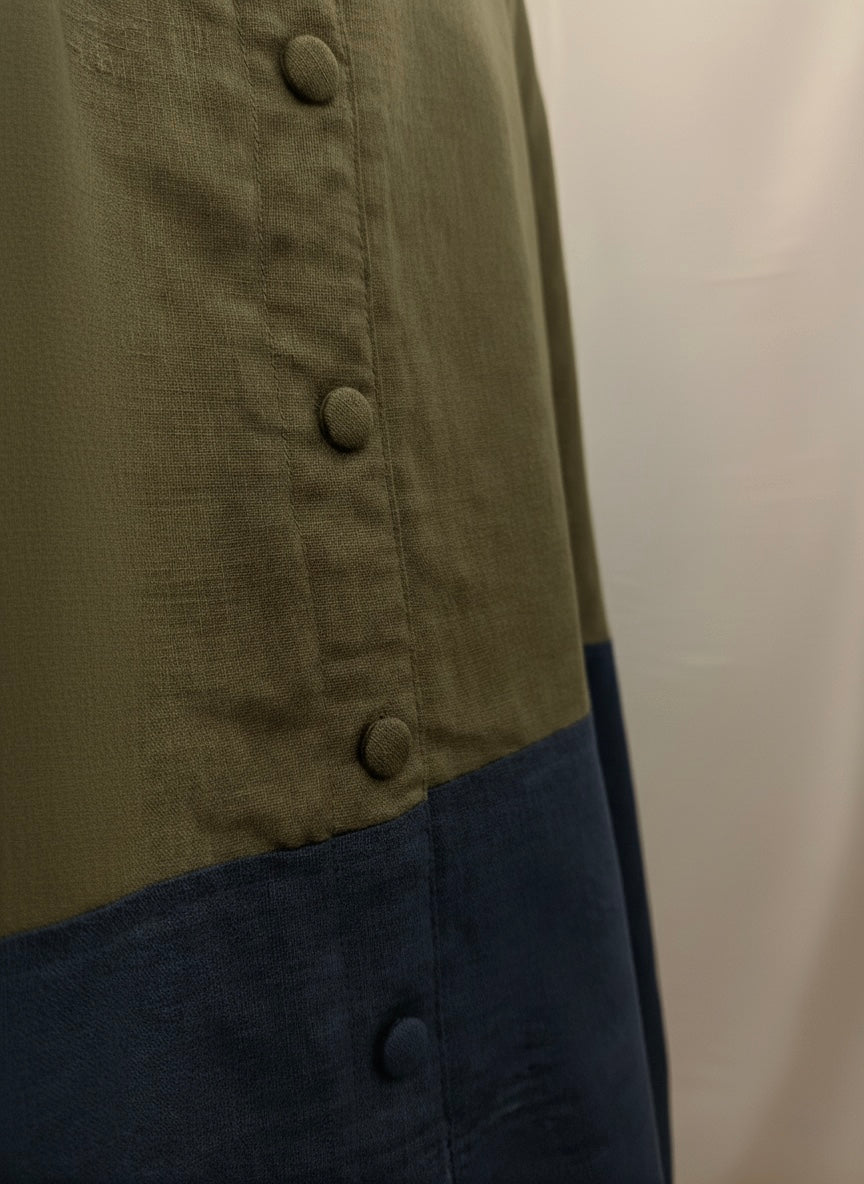 Close-up of a buttoned shirt with a color-block design on a plain background