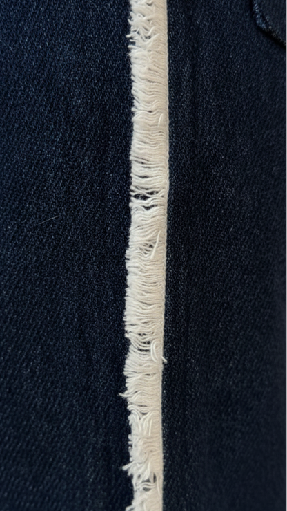 Close-up of a navy blue fabric with a white frayed edge