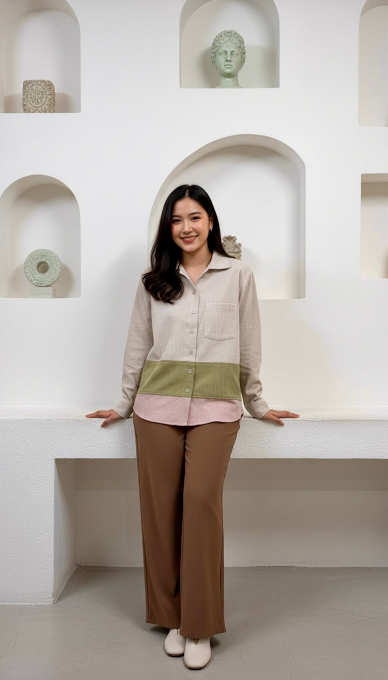Woman standing in a modern interior setting with white walls and shelves.