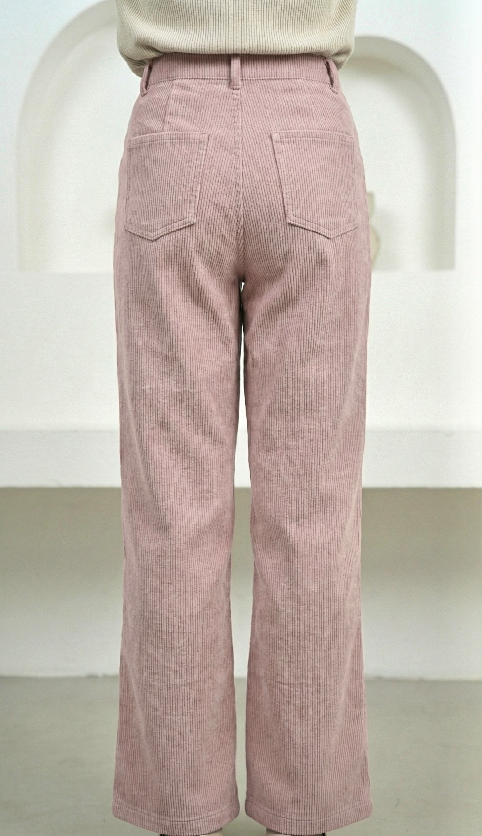 Pink corduroy pants on a white background