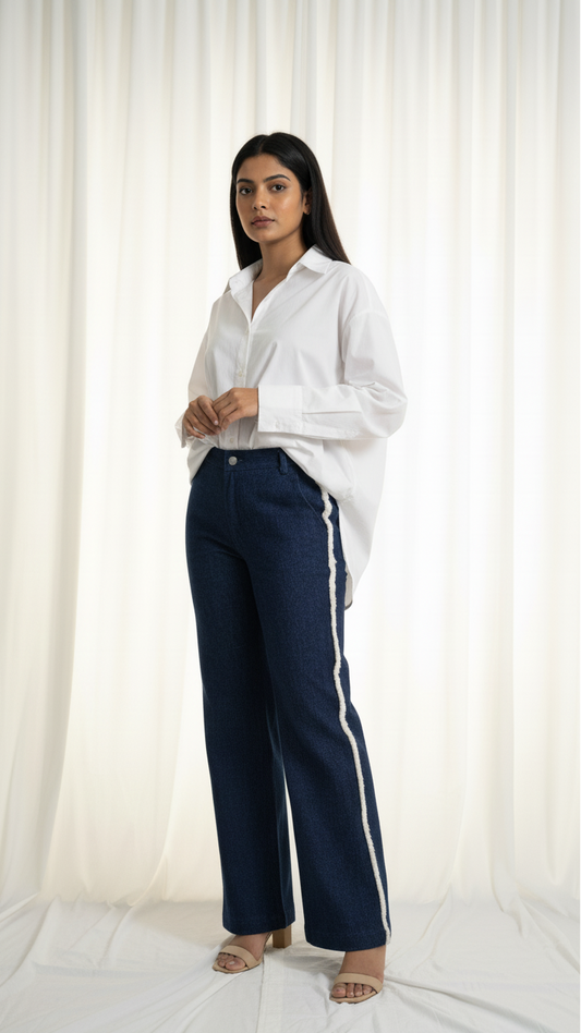 Woman wearing a white shirt and navy pants with a white background