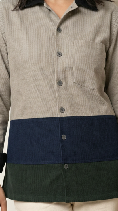 Person wearing a shirt with a color-blocked design featuring beige, navy, and green.
