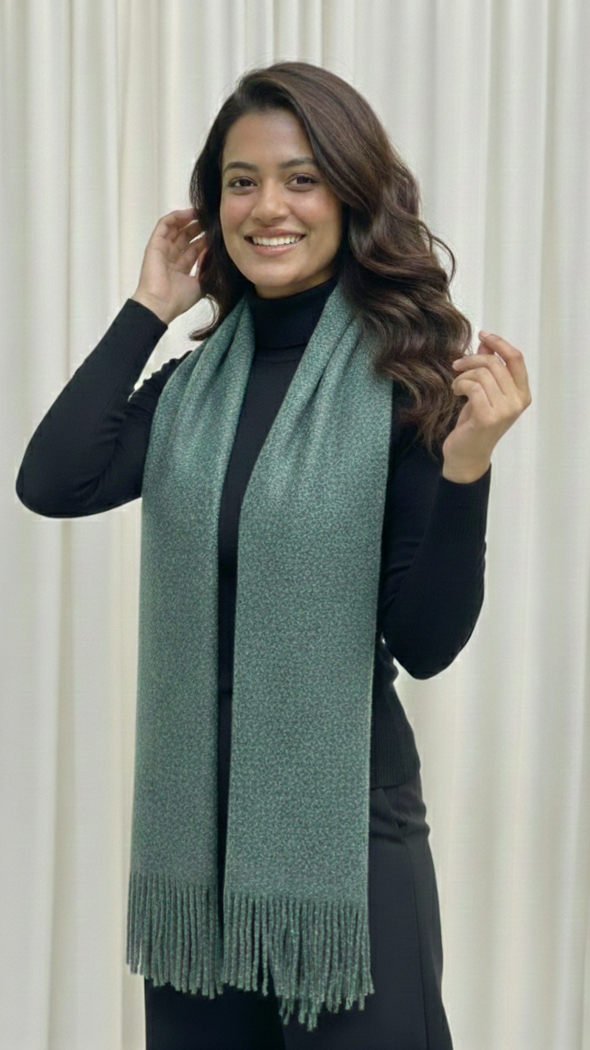 Woman wearing a green scarf against a white curtain background