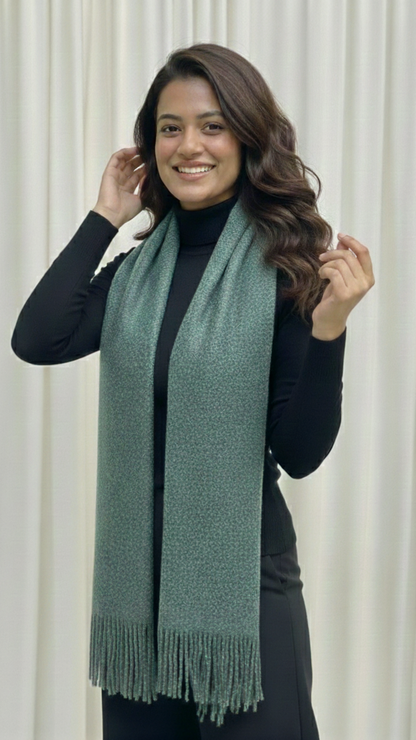 Woman wearing a green scarf against a white curtain background