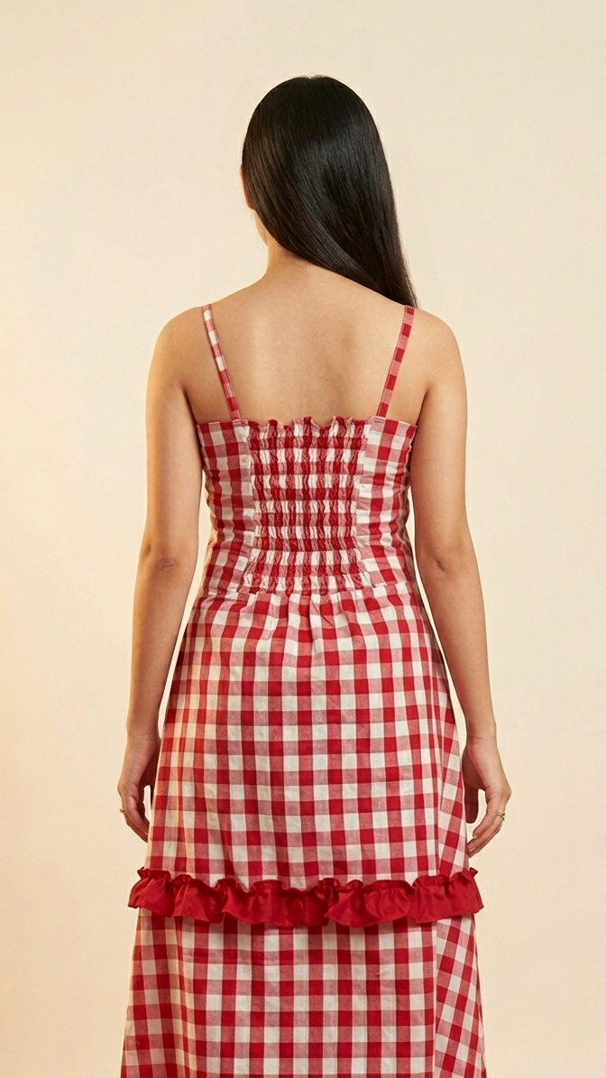 Woman wearing a red and white checkered dress with ruffled details on a beige background