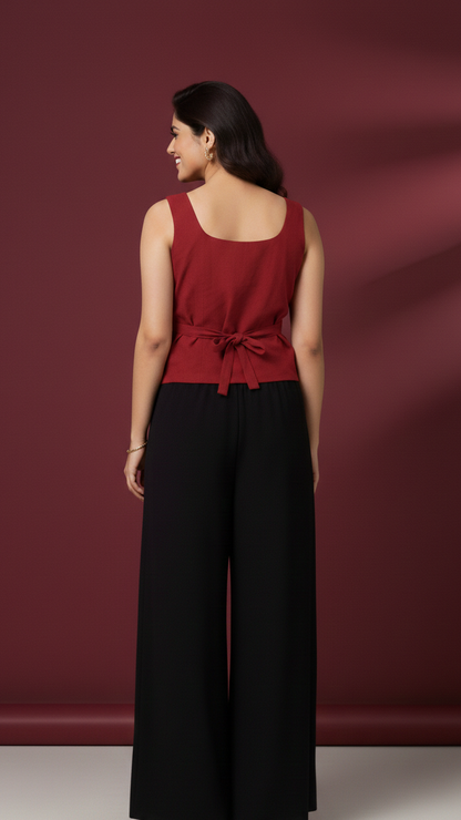 Woman wearing a red top and black pants against a maroon background