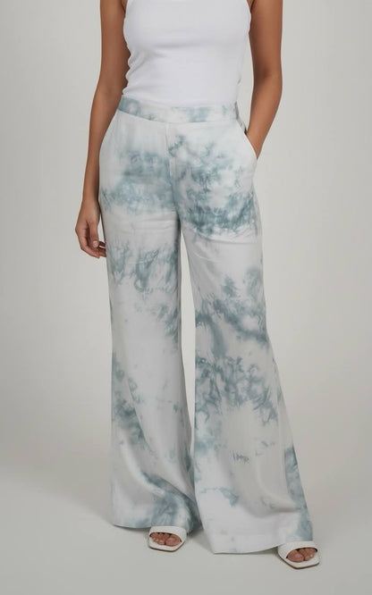 Person wearing light blue tie-dye pants on a plain background