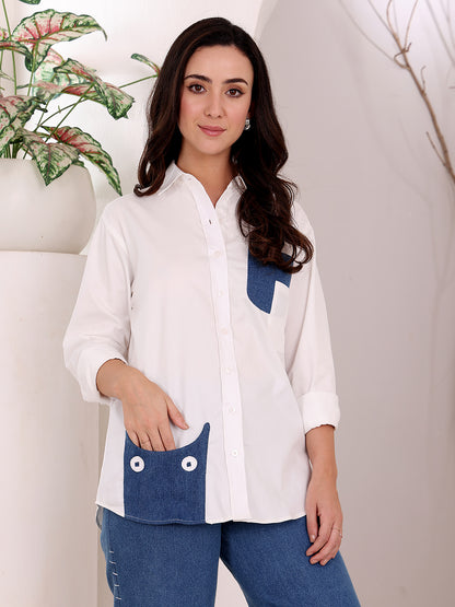 Woman wearing a white shirt with blue accents against a neutral background